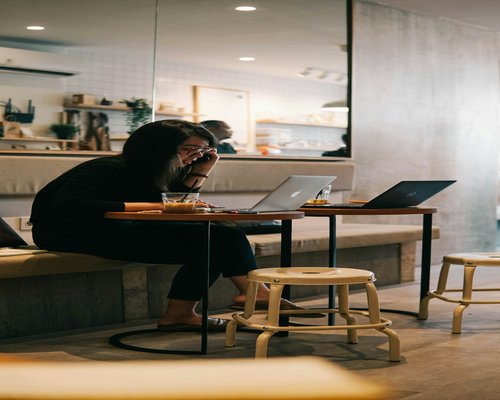 Small editorial team working together on laptop in Jakarta coworking space