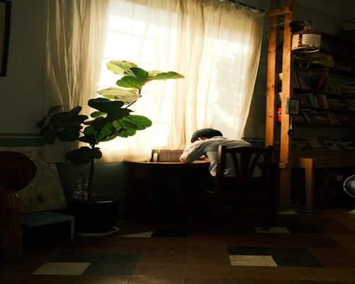 Tropical sunlight streaming through window onto reading desk in Indonesian home